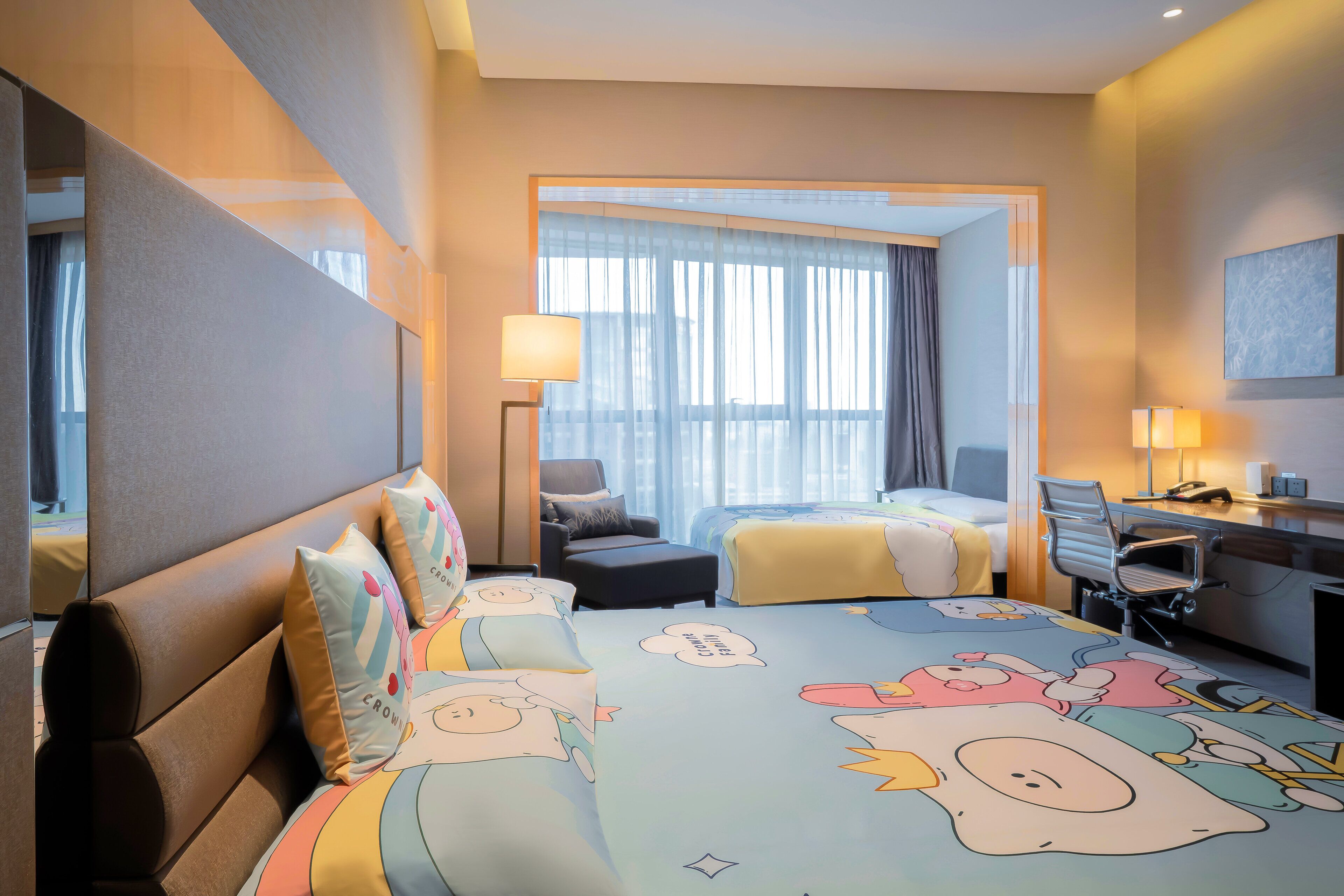 Una habitación de hotel con una cama grande, un escritorio, una silla y una ventana con cortinas.