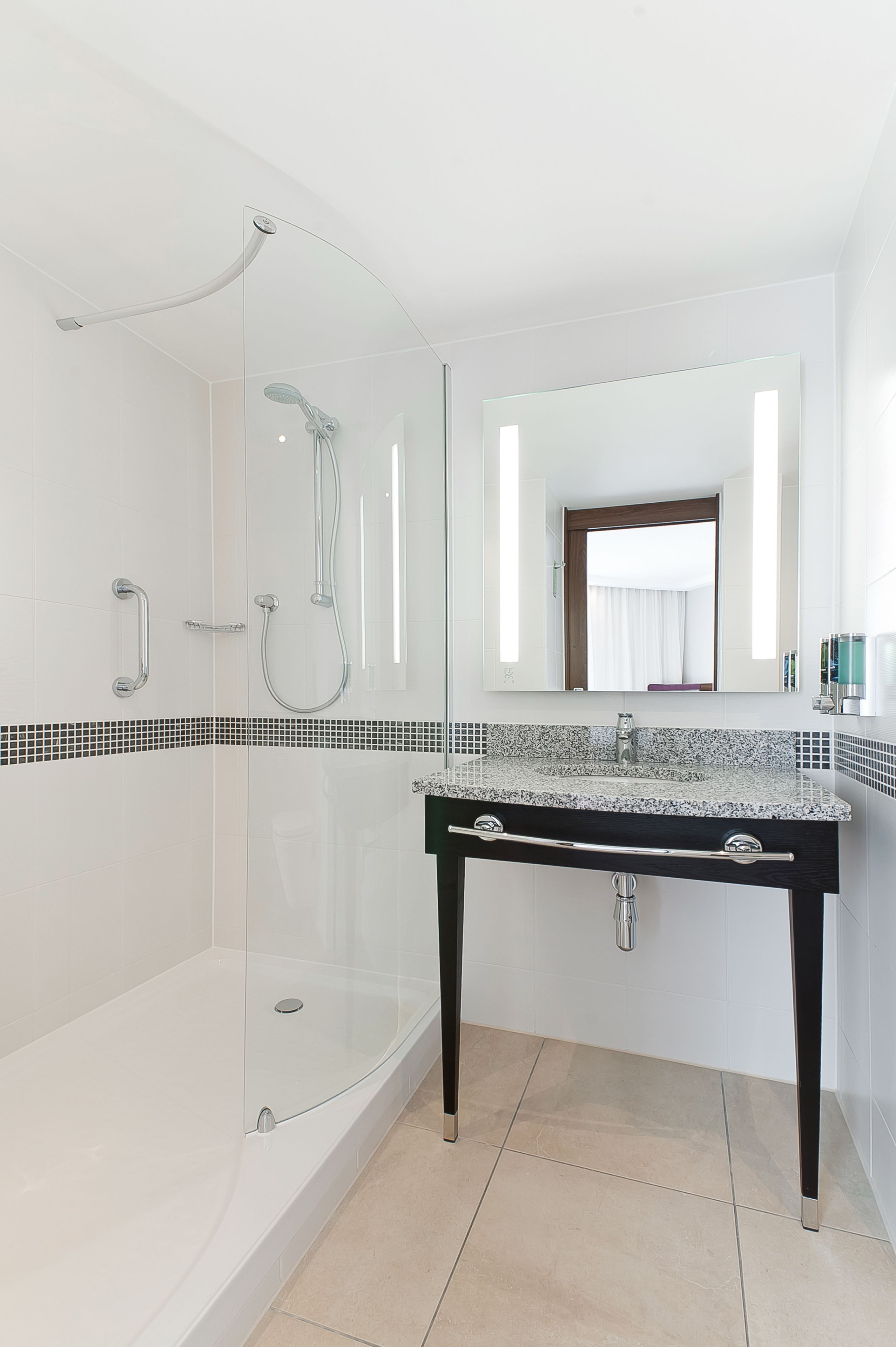 Une salle de bain moderne avec une douche à parois de verre, un lavabo en granit et un grand miroir.