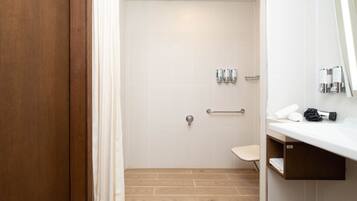 Un baño moderno con ducha, inodoro y lavamanos.