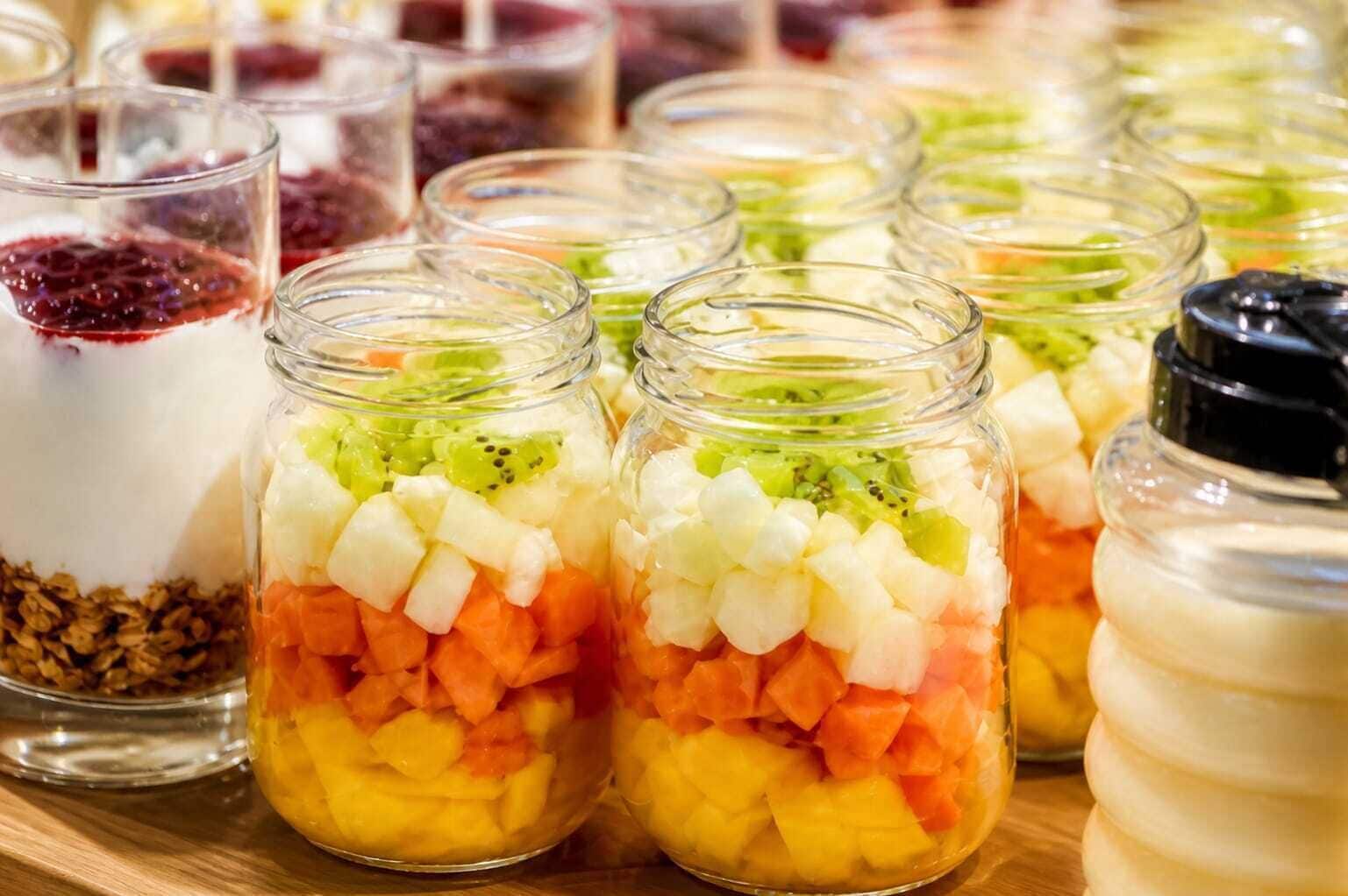 A variety of food items in jars, including fruits and yogurt.