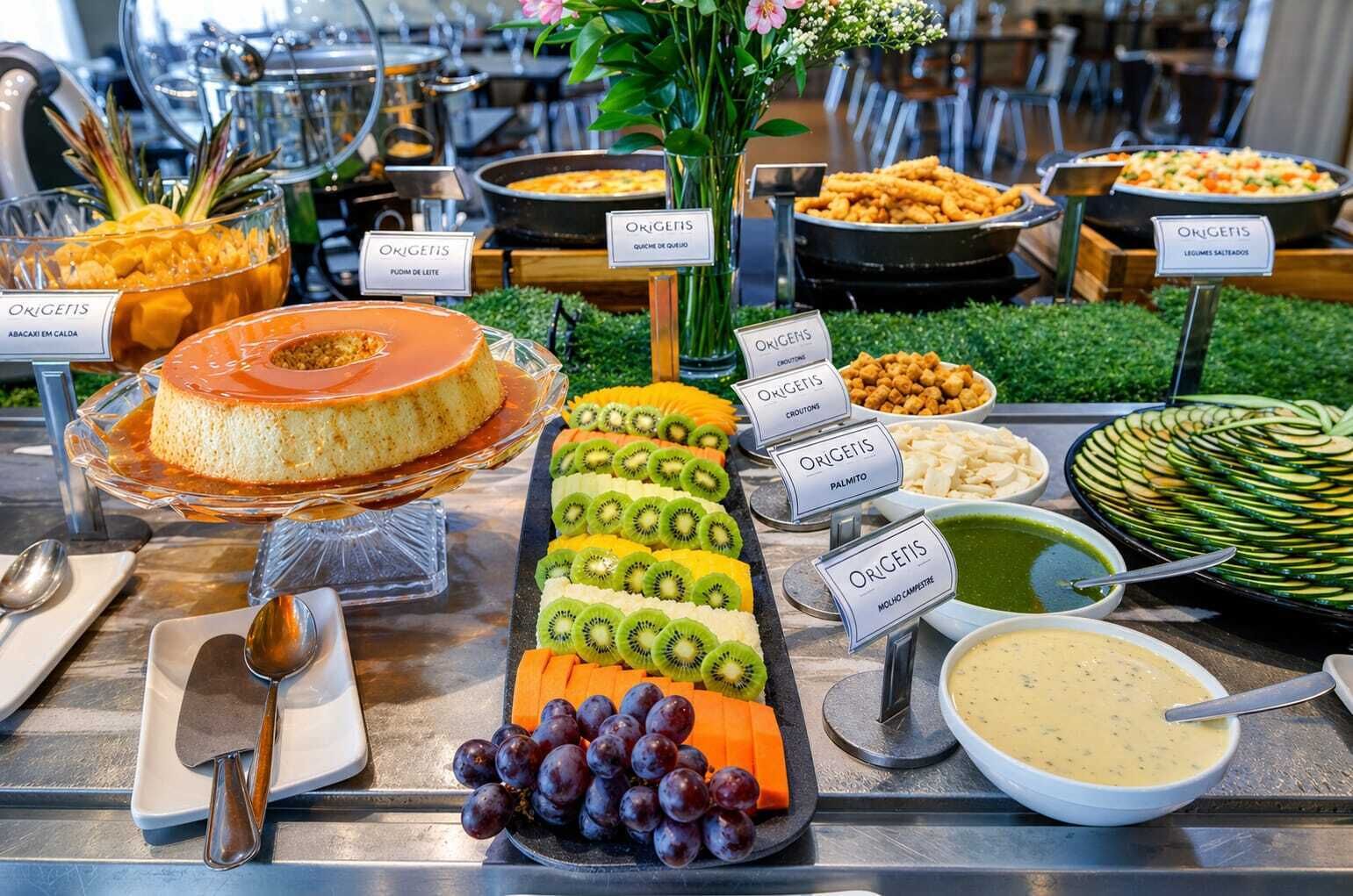 Un buffet con diversi cibi ed etichette, tra cui una torta, frutta e vari piatti.