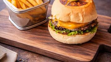 Una hamburguesa con papas fritas sobre una tabla de madera.