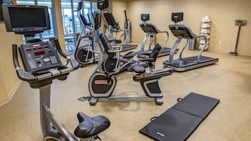 A gym with various exercise machines, a treadmill, and a stationary bike.