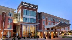Un hotel Doubletree by Hilton con fachada de ladrillo moderno, ventanas amplias y entrada cubierta.