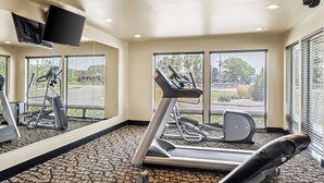 A gym with treadmills, a stationary bike, and a mirrored wall. - Ledgestone Suites Hotel Billings (Billings)