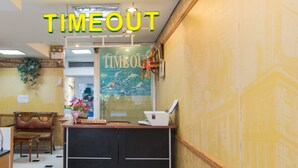 A reception area with a reception desk, a mirror, and a wall with a 'TIMEOUT' sign. - Time Out Hotel Beach Front (Patong)