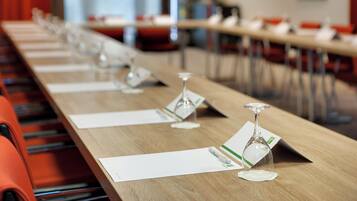 Un salón de conferencias con una larga mesa, sillas y tarjetas de identificación.
