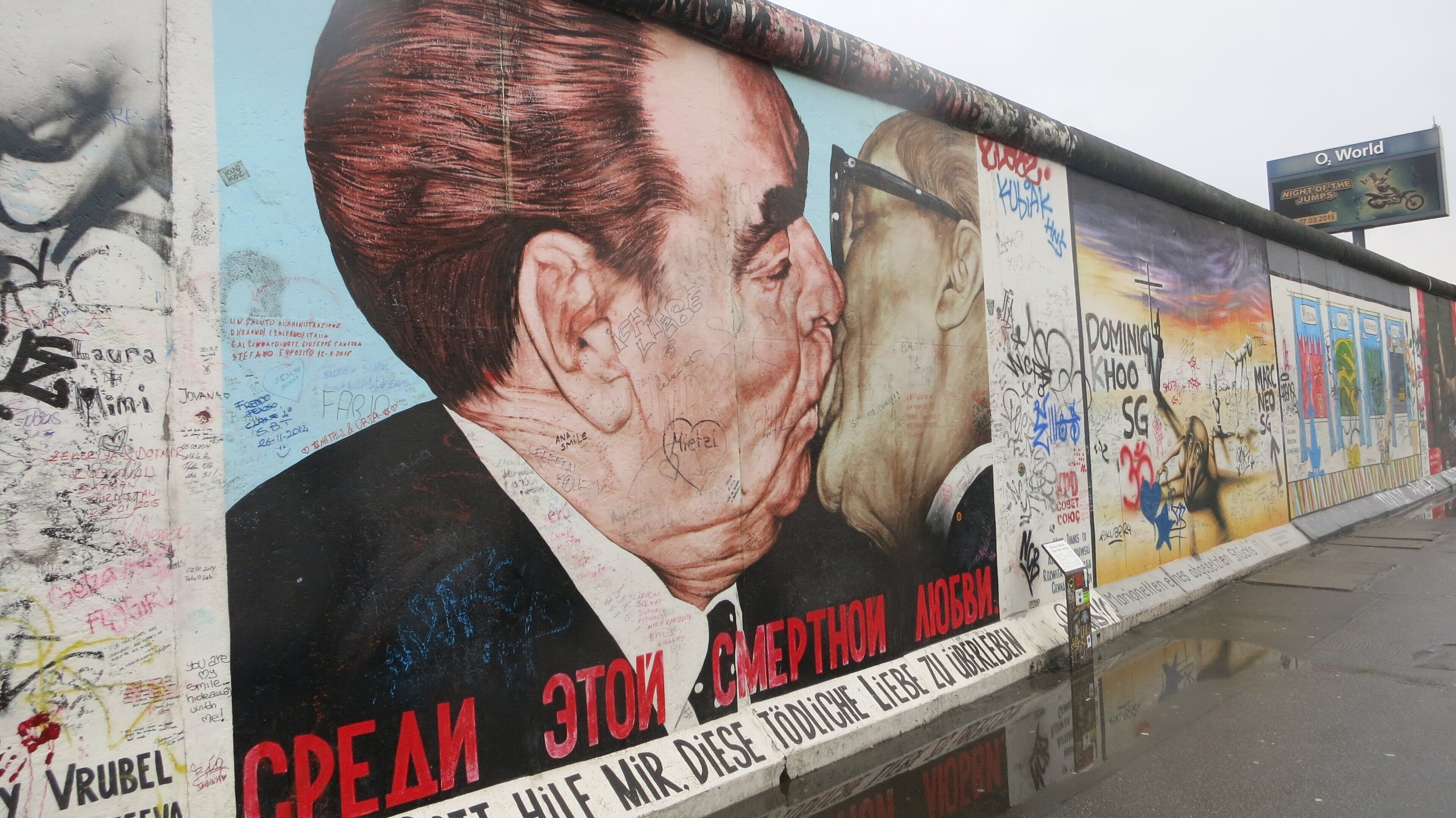 Paredes com grafite e um grande anúncio com a imagem de um homem.