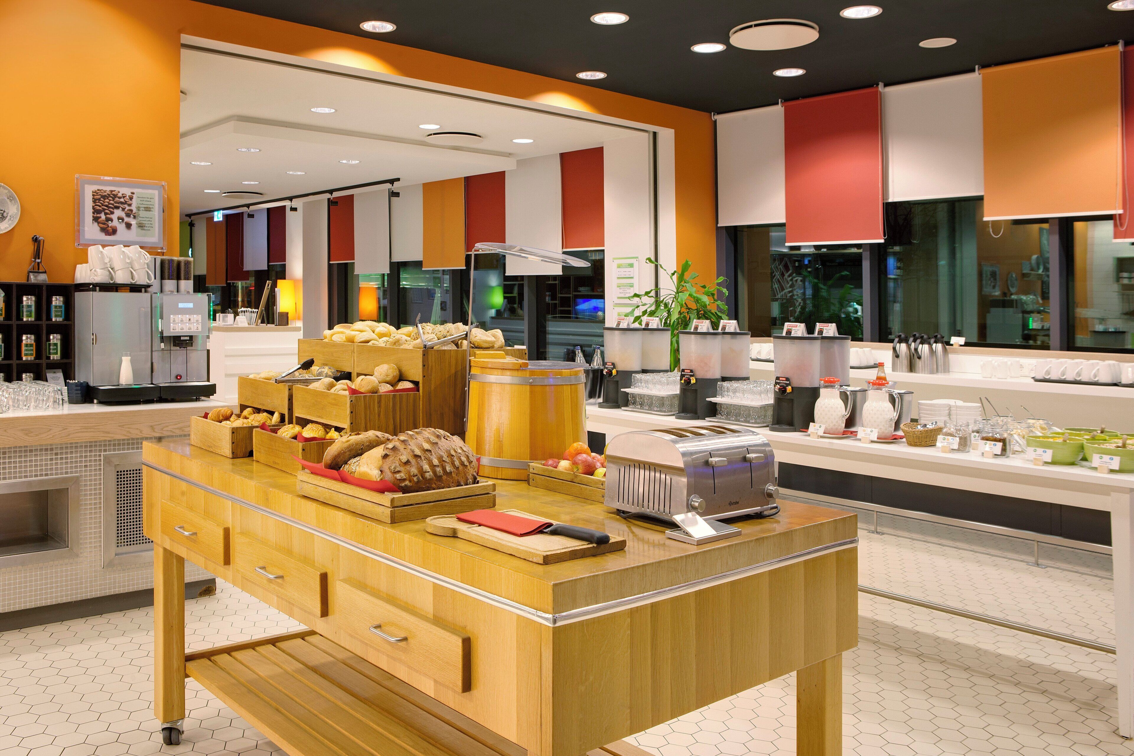 A breakfast buffet with various baked goods and a coffee station.
