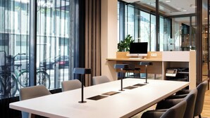 A modern conference room with a long table, chairs, a flat-screen TV, and a laptop. - Holiday Inn Berlin - City East Side by IHG (Berlin)