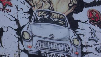 Pared con grafitis, incluyendo un coche y un emblema de estrella.