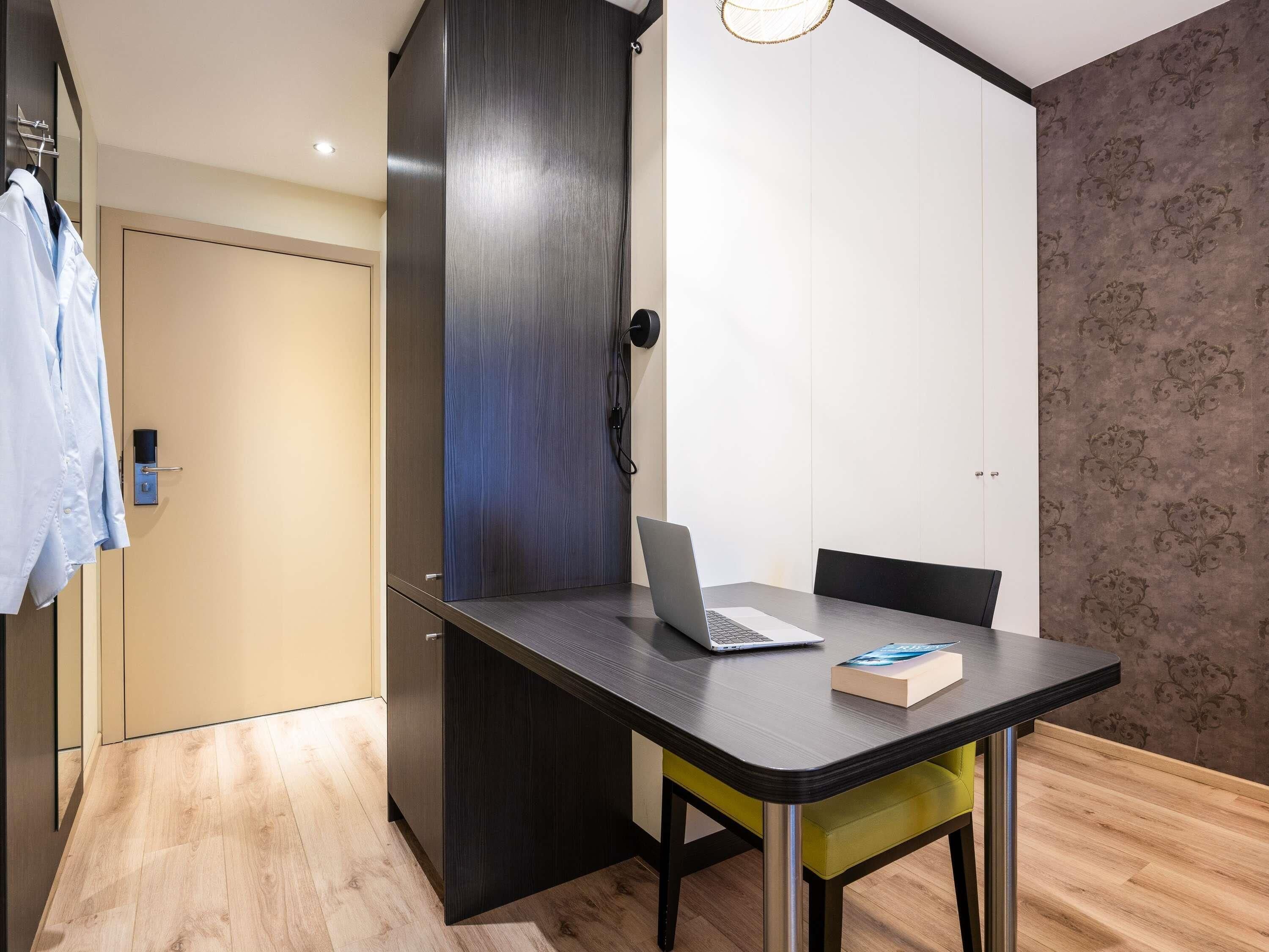 Una habitación moderna con un escritorio, una silla y una computadora portátil.