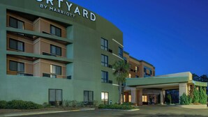 Ein Courtyard by Marriott Hotel mit modernem Design, mehreren Etagen und einem gut beleuchteten Eingangsbereich.