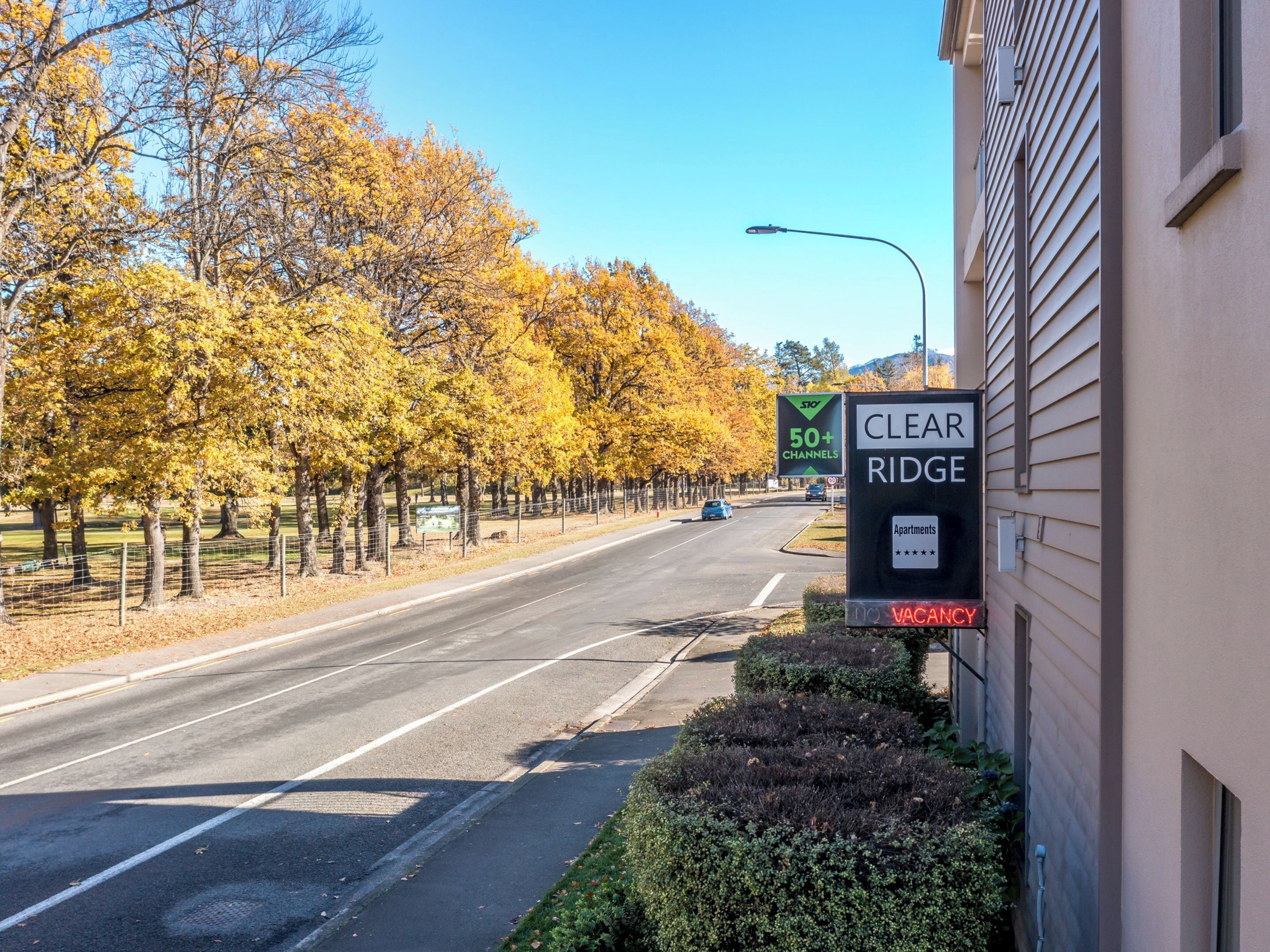 Una calle con un cartel de Clear Ridge Apartments, que indica más de 50 canales y sin disponibilidad.