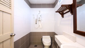 Une petite salle de bain avec des toilettes, une douche et un lavabo.