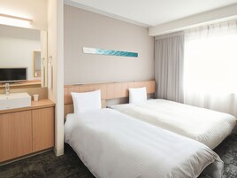 Cubrecamas, escritorio y espacio para trabajar con laptop 