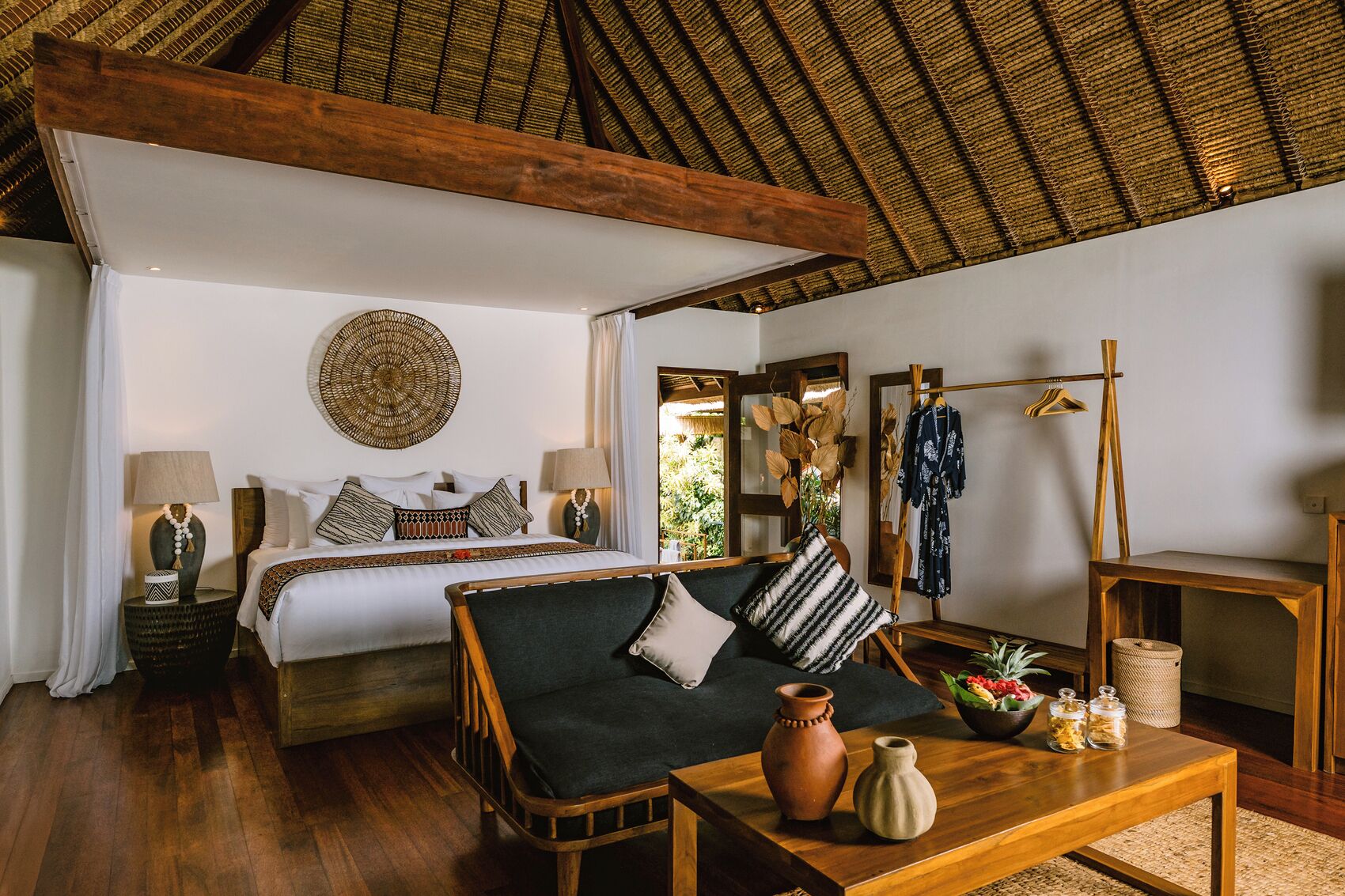 Une chambre à coucher avec un lit, un canapé, une table basse et un miroir.