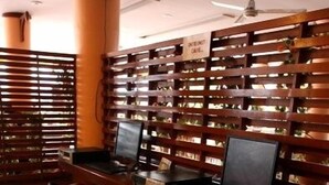 A workspace with two computers, a wooden partition, and metal chairs. - Queen Pattaya Hotel (Pattaya)
