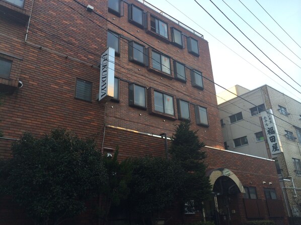A multi-story brick building with a sign that reads "FUKUDAYA" and another sign with Japanese characters. - Asakusa Fukudaya (Tokyo)