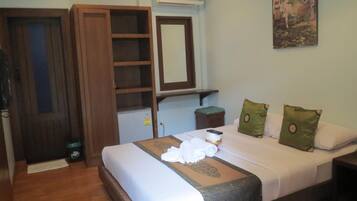 Habitación de hotel con cama, armario, espejo, aire acondicionado y un cuadro en la pared.