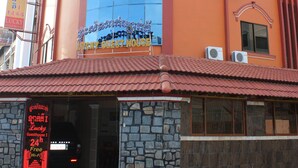 A building with a curved facade, large windows, and a sign indicating it is a guest house. - Lucky 1 Guesthouse (Phnom Penh)