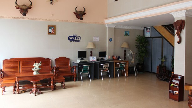 Un vestíbulo con mostrador de recepción, zona de estar y una escalera.