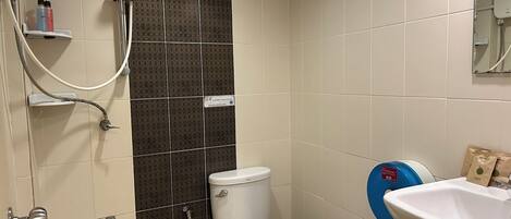 Un baño con inodoro, ducha y lavabo.