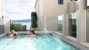 A swimming pool with clear water, surrounded by a modern building with large windows. - Boulevard Waters (Taupo)