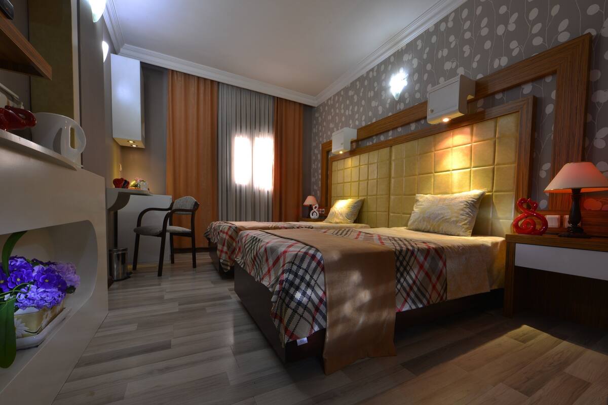 A hotel room with a bed, a desk, and a chair.