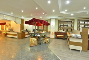 A spacious hotel lobby with a buffet area, a reception desk, and a large chandelier. - Sevcan Hotel (Istanbul)