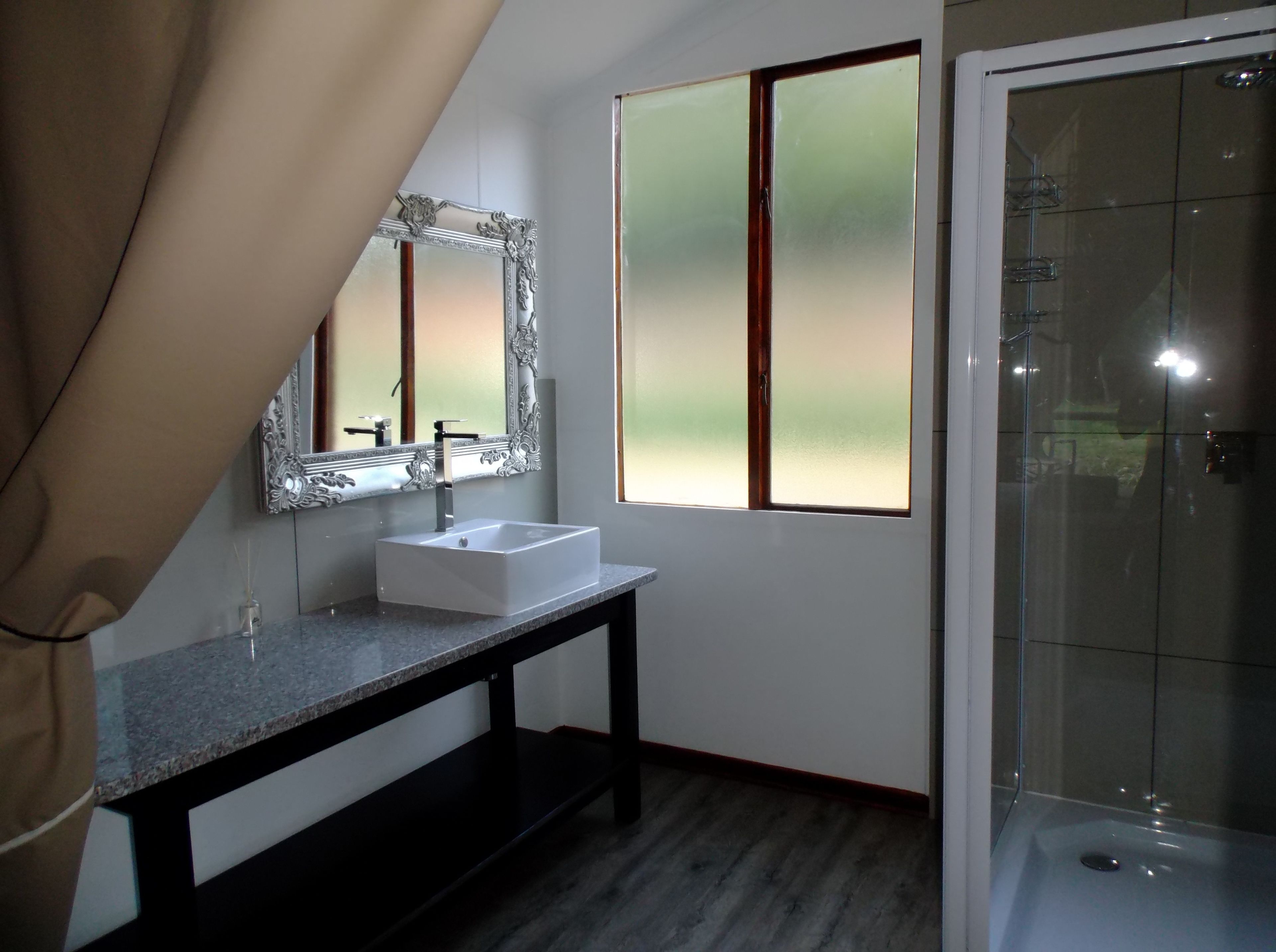 A bathroom with a white sink, a large mirror, and a shower.