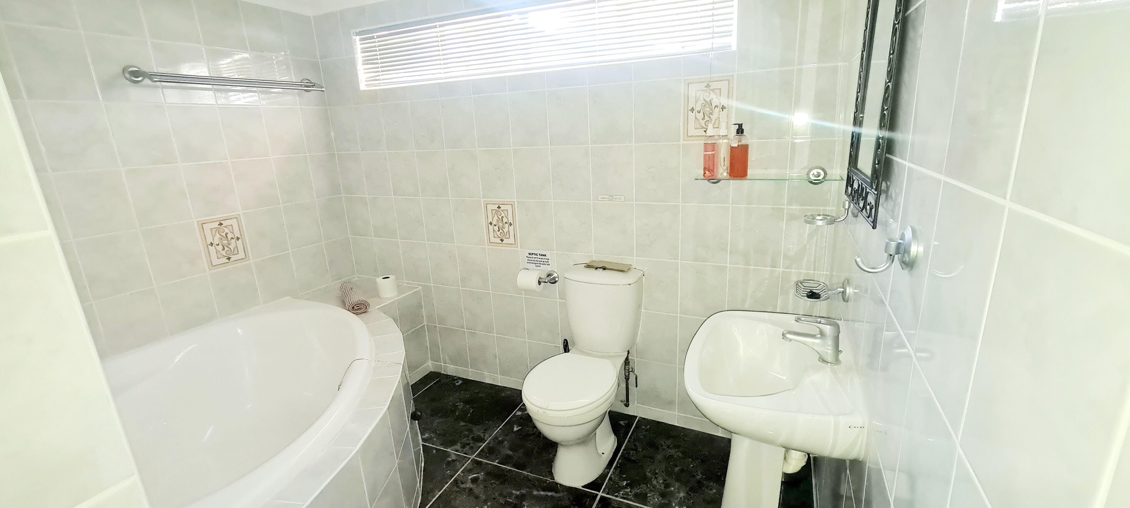 A bathroom with a bathtub, toilet, and sink.