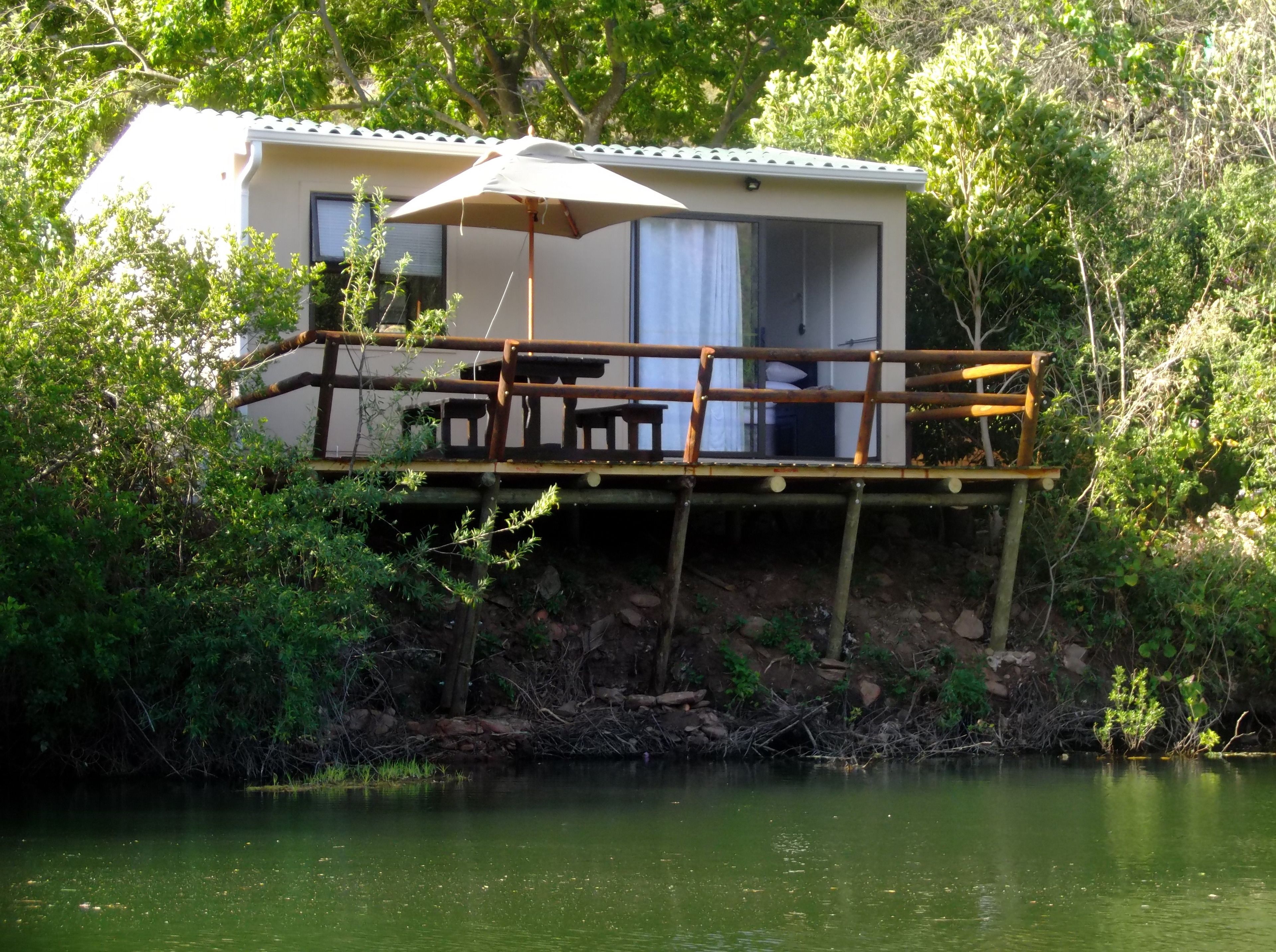 A cabin with a deck, a table, and a chair.