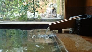 Une terrasse en bois agrémentée d’un élément aquatique.