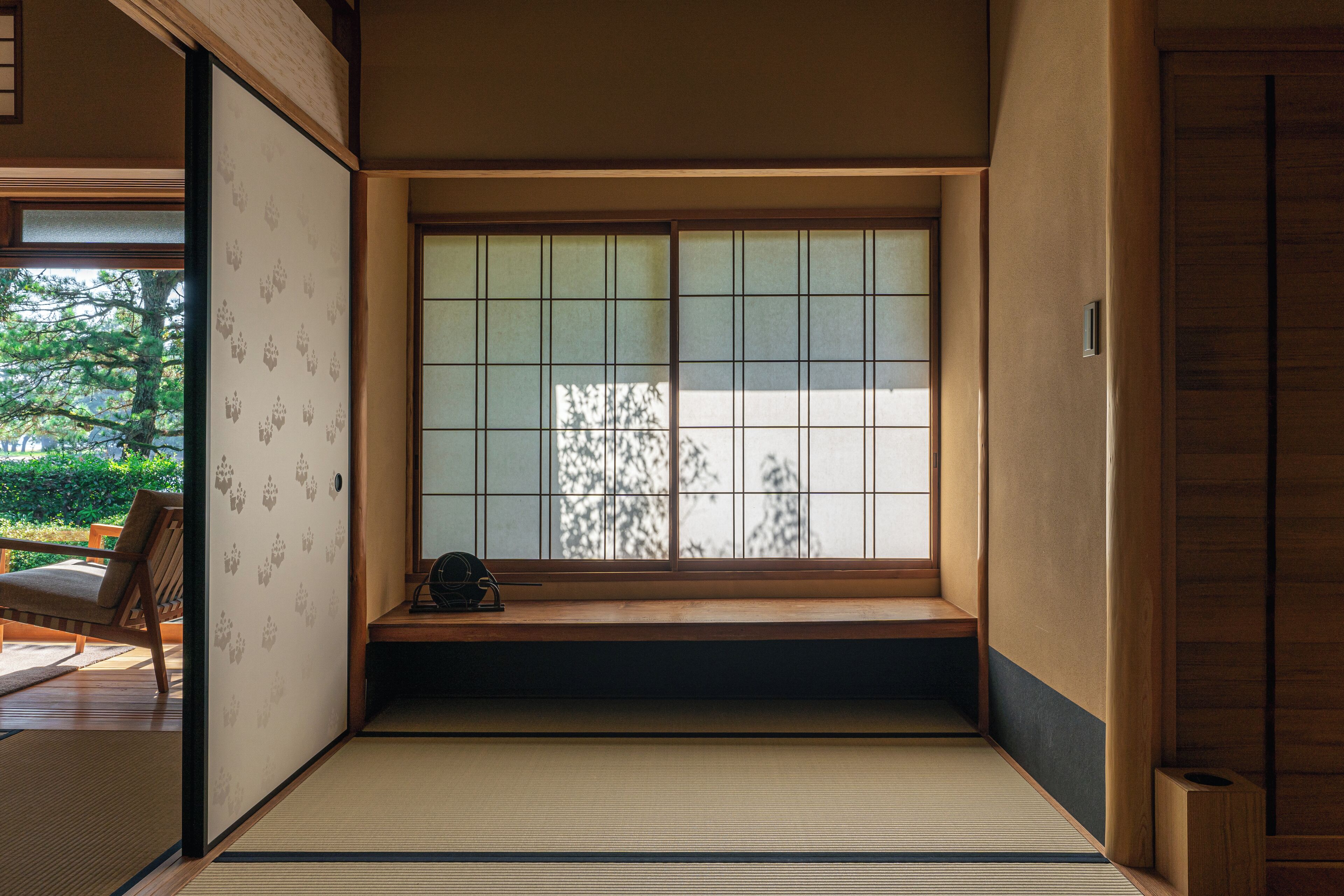 A traditional Japanese room with tatami flooring, a shoji screen window, and a wooden bench.