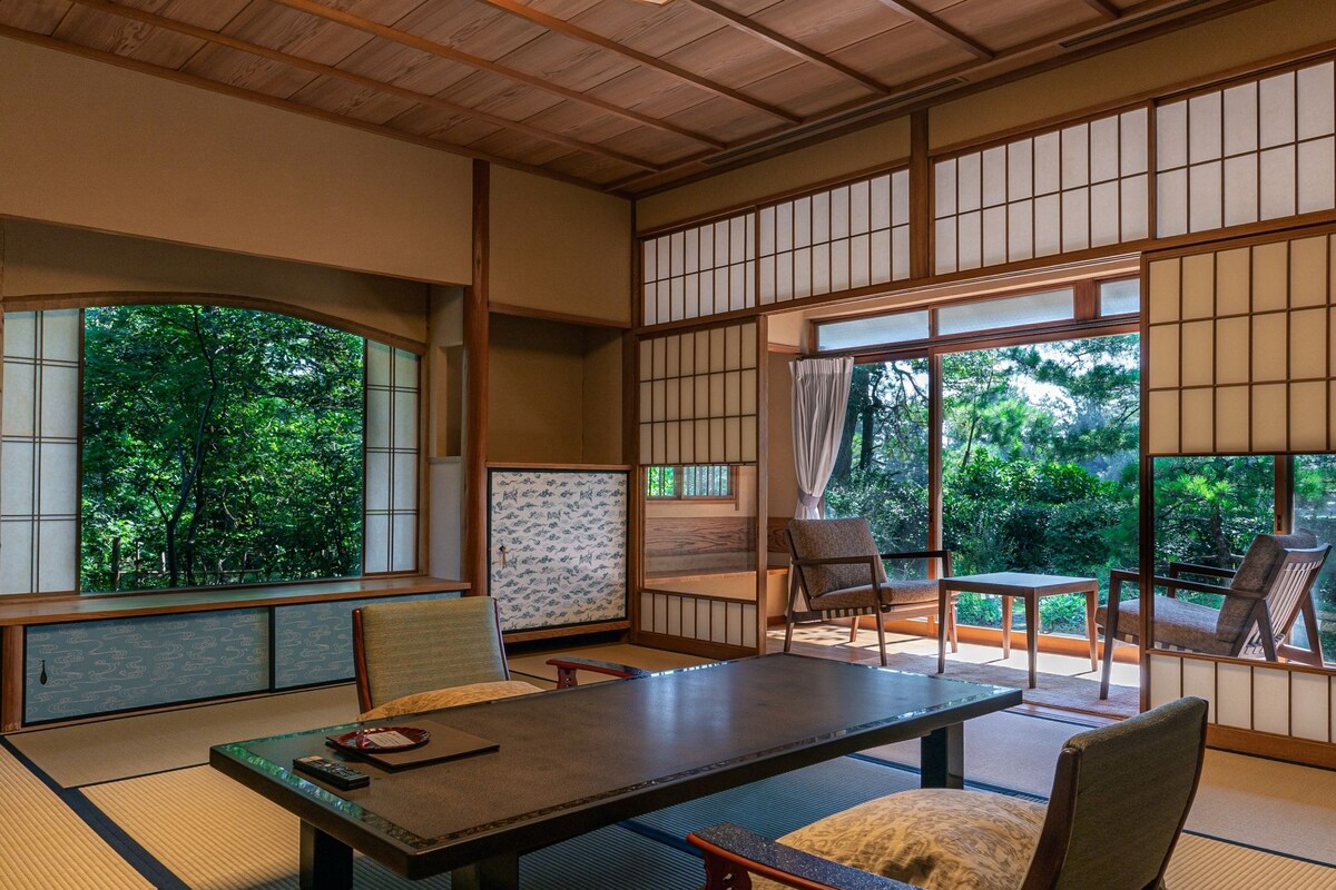Um quarto em estilo japonês tradicional, com tatames, uma mesa baixa e biombos shoji.