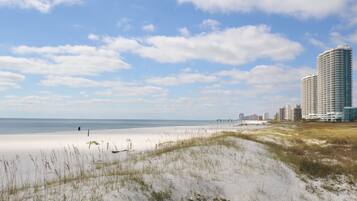On the beach, white sand, sun loungers, beach umbrellas