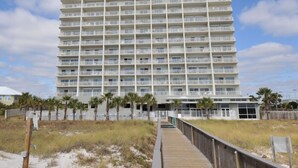 A multi-story hotel with a flat roof, balconies, and a beachside location.