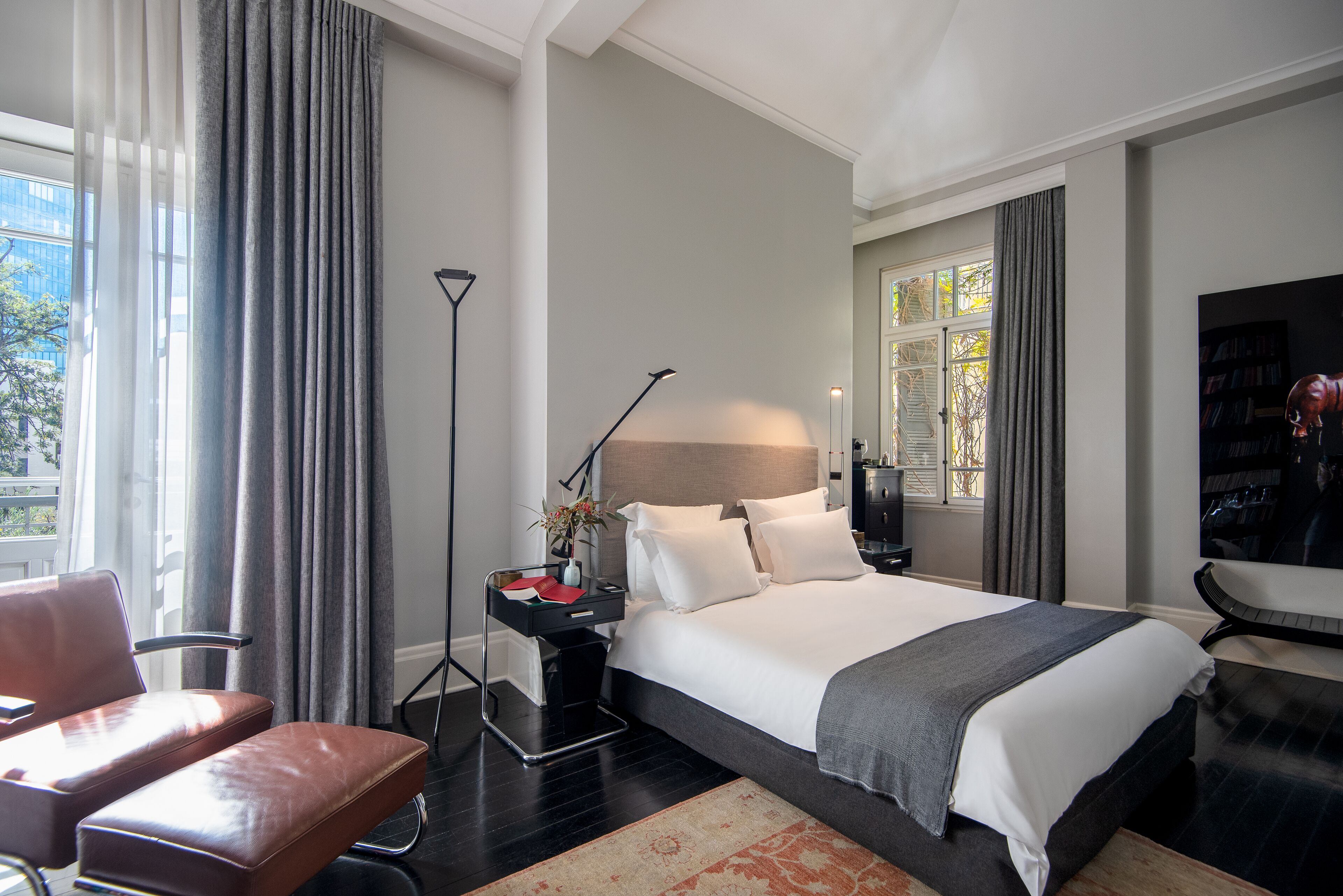 Una habitación de hotel moderna con una cama grande, un escritorio, una silla y un televisor.
