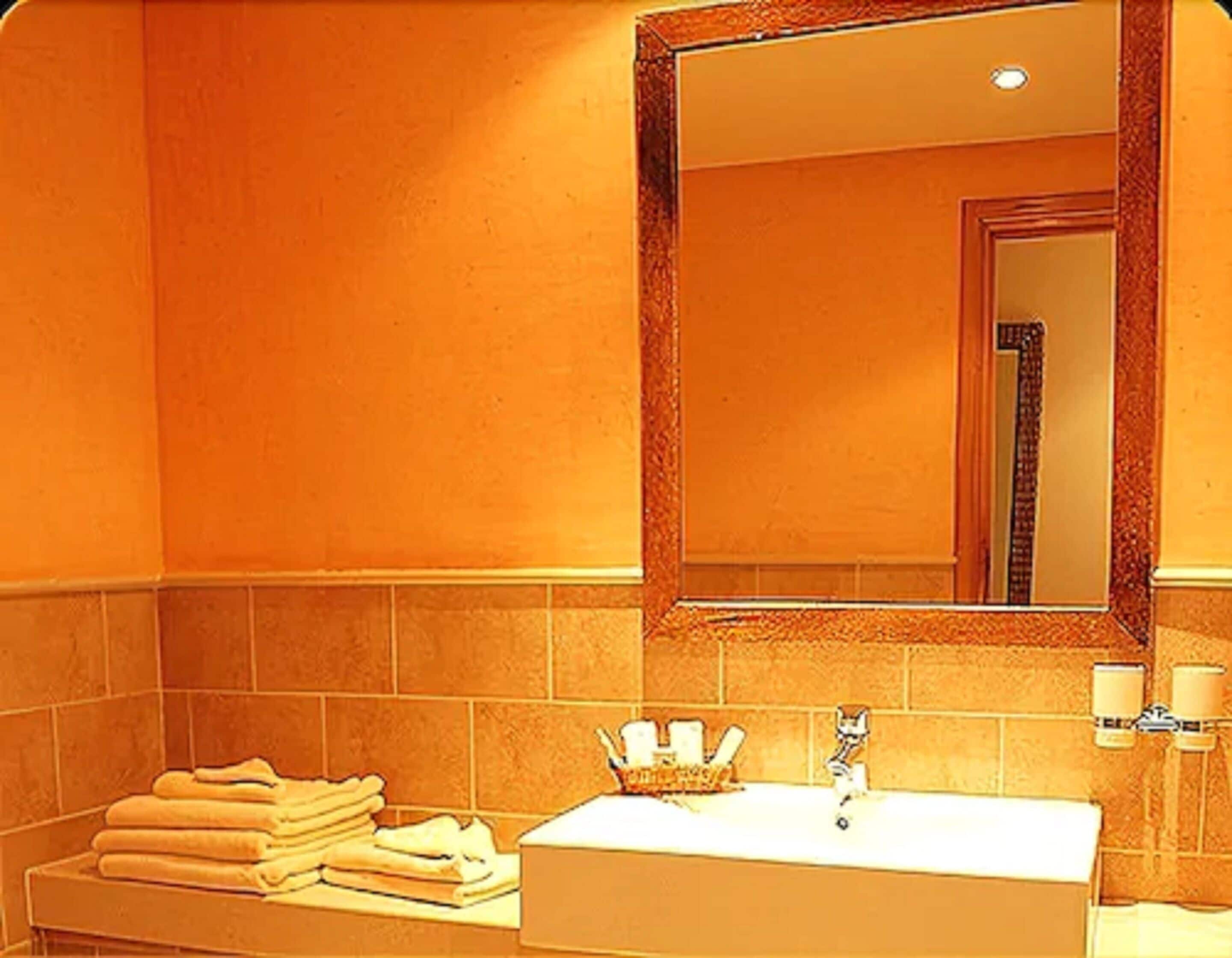 Une salle de bain avec un lavabo, un miroir et des serviettes.