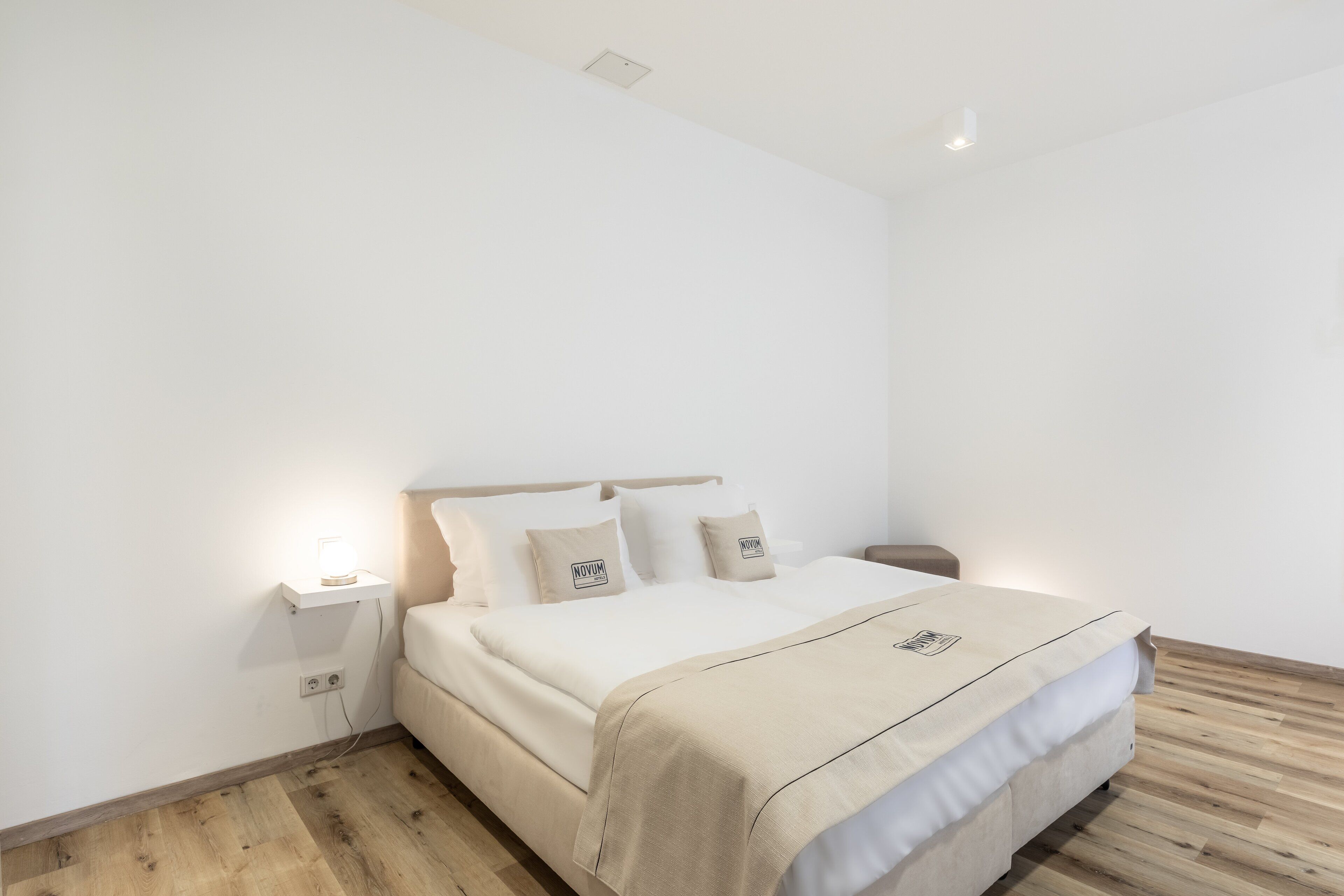 A minimalist bedroom with a bed, bedside tables, and a nightstand.