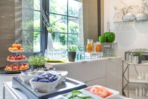 Un buffet de petit-déjeuner comprenant des fruits, des légumes et des boissons.