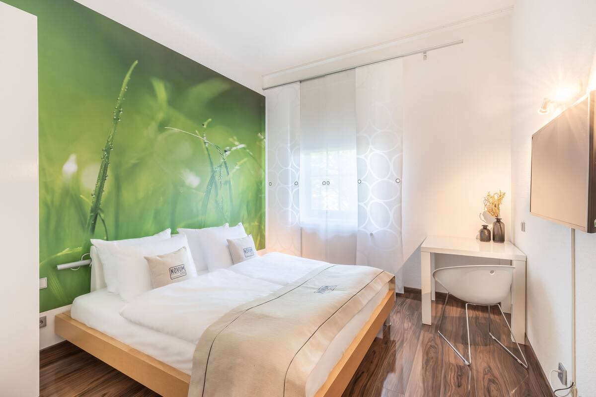 Une chambre d’hôtel moderne, équipée d’un lit, d’un bureau et d’une chaise.