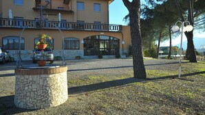 A building with a sign reading "Hotel Ristorante" and a stone fountain with a potted plant. - Villa Hotel del Sole (Chiusi)