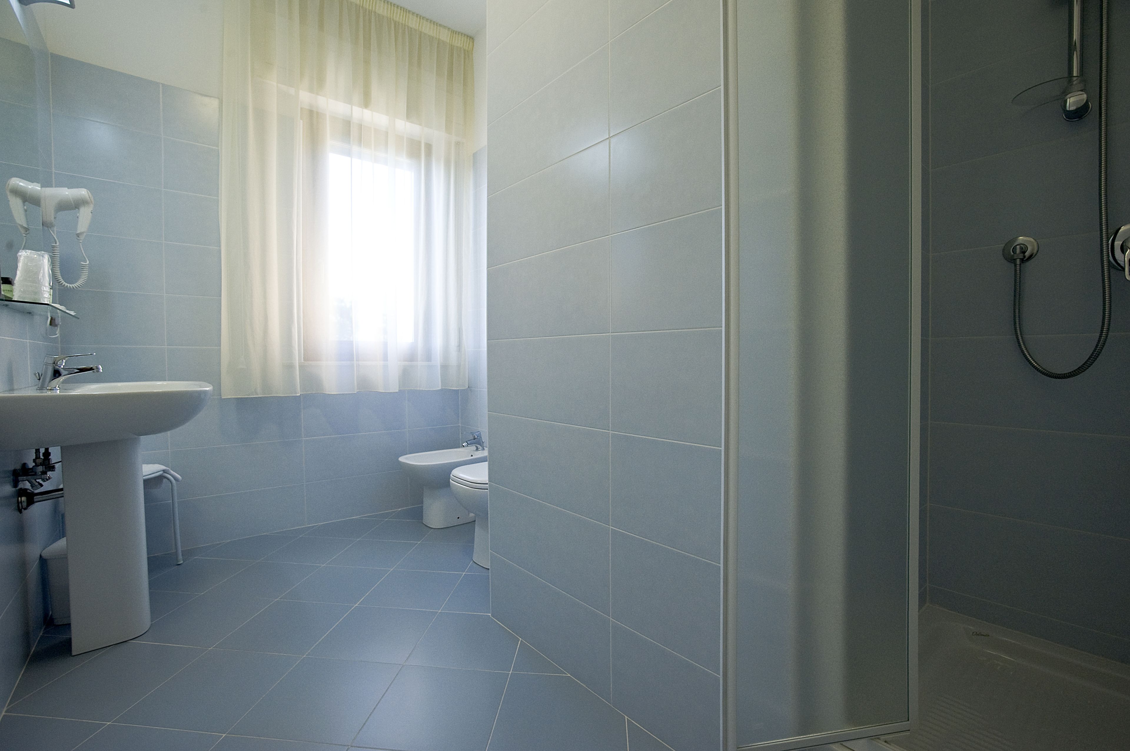 A modern bathroom with a sink, toilet, and shower.