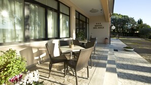 An outdoor seating area with wicker chairs and tables, a sign reading "HOTEL DEL SOLE", and potted plants. - Villa Hotel del Sole (Chiusi)