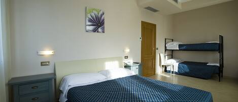 A bedroom with a large bed, a smaller bed, a nightstand, a dresser, and a painting on the wall.