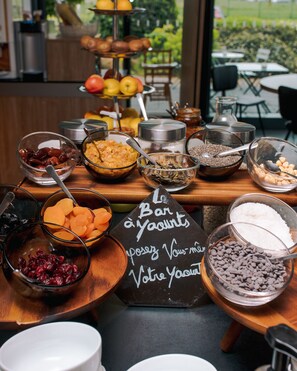 Une table de buffet garnie de différents plats et un panneau noir servant de menu.