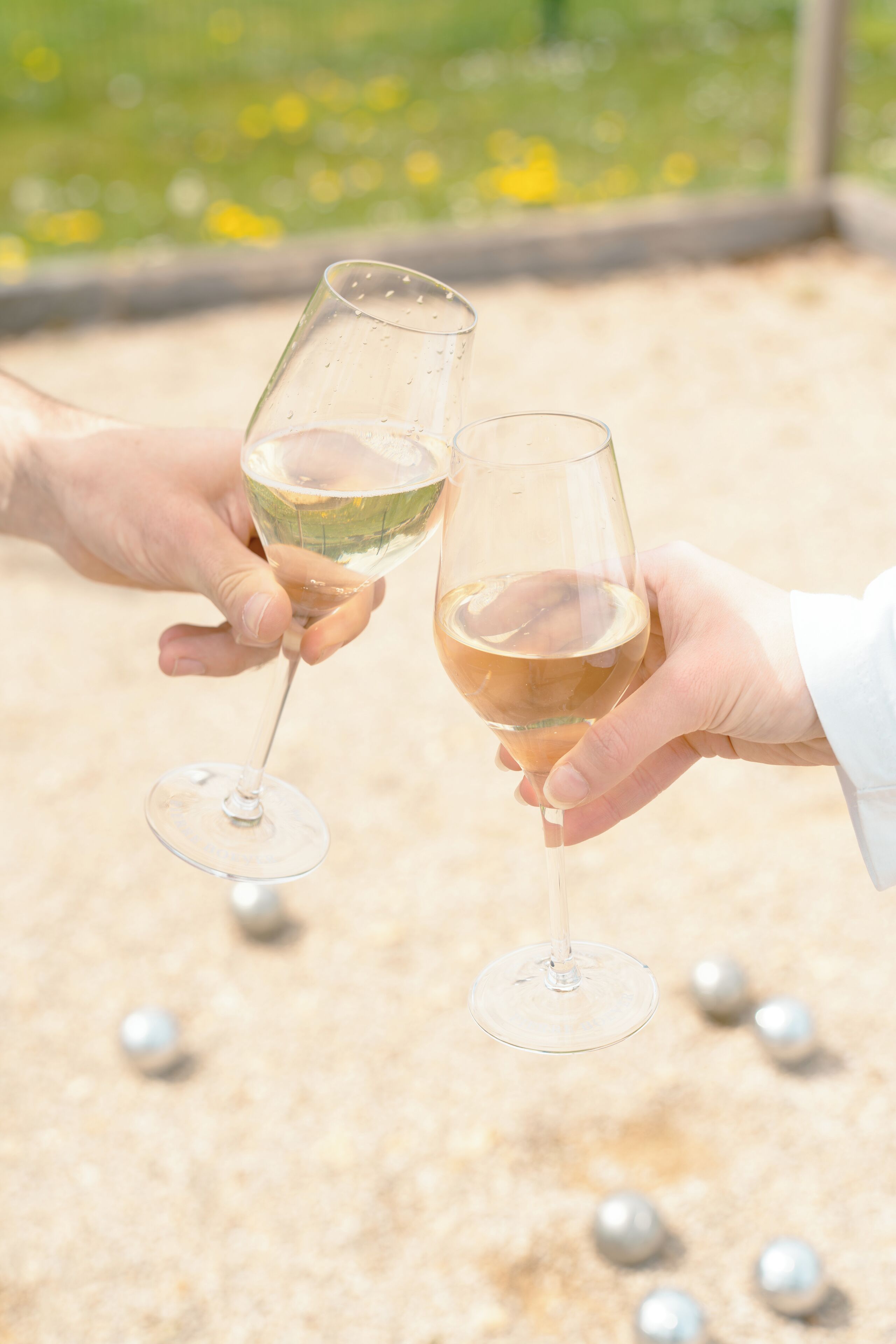 Two hands holding wine glasses.