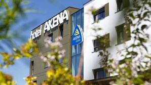 Un hôtel moderne dont le nom, « AKENA », est clairement affiché sur la façade.